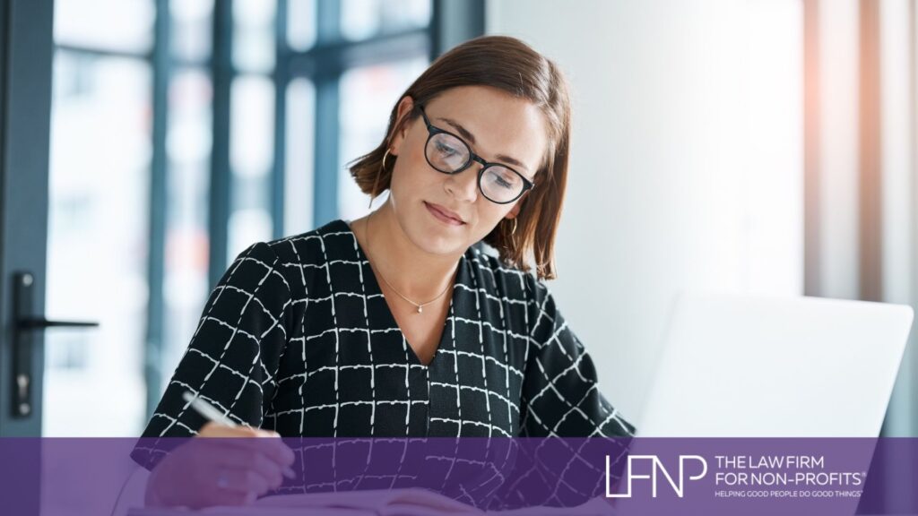Professional woman reviewing documents at a desk with a laptop, representing nonprofit leaders managing public charity compliance and IRS public support requirements.