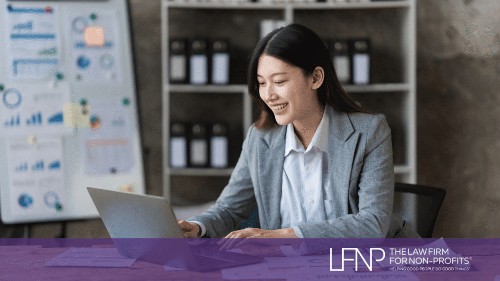 Woman sitting at desk smiling, reviewingnHow Nonprofits Maintain Public Charity Status | LFNP